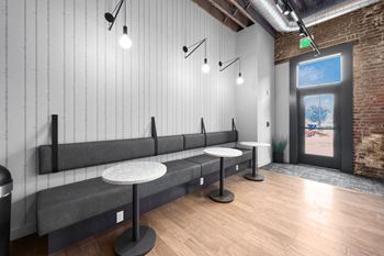 A room with a long bench and a table with a plant on it.at Plant 1 Lofts, N. Newton, 50208  